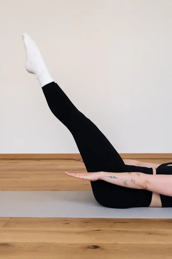 Pilates-Mattenübung mit gestrecktem Bein und aktivierter Körpermitte