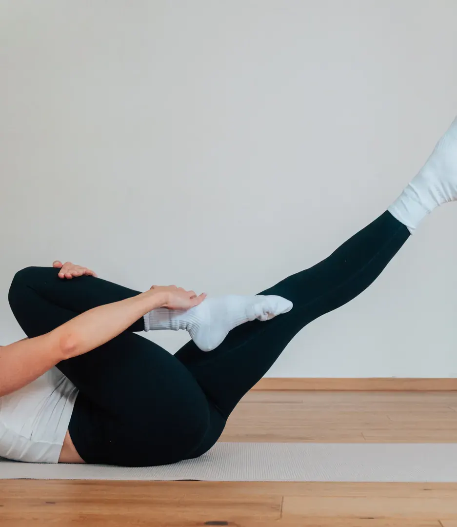 Klassische Pilates-Übung Single Leg Stretch auf der Matte